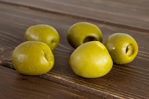 Aceituna verde con hueso sobre madera marrón —  Fotos de Stock