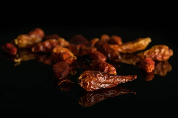 Suche czerwone papryka Pepperoncino izolowane na czarnym szkle — Zdjęcie stockowe
