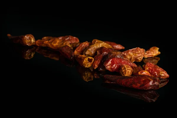 Dry red pepperoncino pepper isolated on black glass — Stock Photo, Image