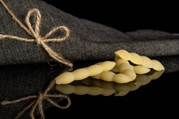 Rå cavatelli pasta isolerad på svart glas — Stockfoto