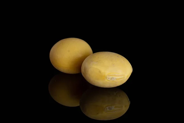 Kacang kedelai kuning mentah yang terisolasi pada kaca hitam — Stok Foto