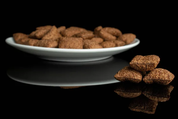 Crispy cereal pillow isolated on black glass