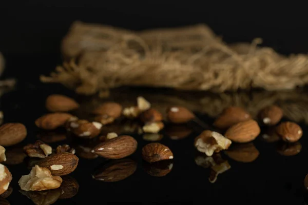 Castanha de amêndoa isolada em vidro preto — Fotografia de Stock