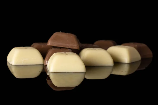 Cioccolato bianco nero isolato su vetro nero — Foto Stock