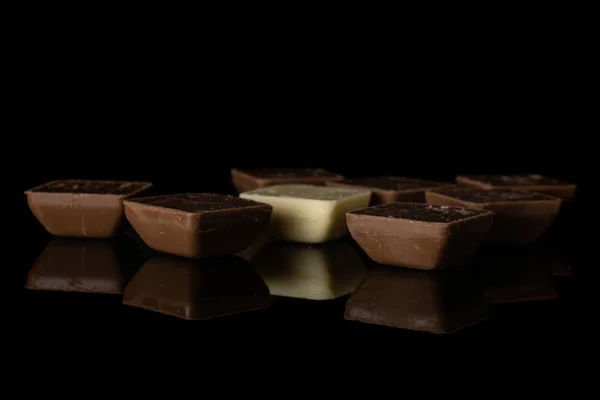 Черный белый шоколад, изолированный на черном стекле — стоковое фото