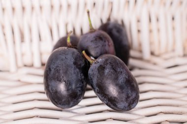 Taze siyah şarap üzümü ve örülmüş rattan