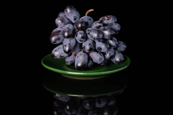 Fresh black wine grape isolated on black glass — Stock Photo, Image