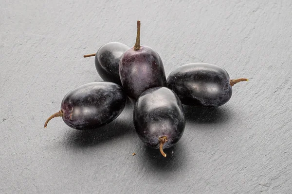 Vin noir frais raisin sur pierre grise — Photo