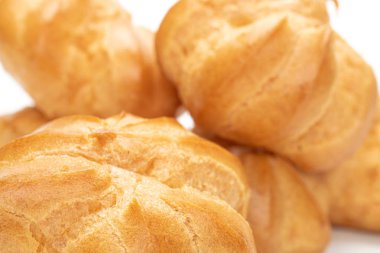 Altın fırınlanmış profiterol beyaza izole edilmiş.