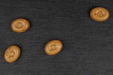 Gri taşın üzerinde kahverengi karamel şekeri