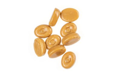 Kahverengi karamel şekerler beyazda izole edilmiş.
