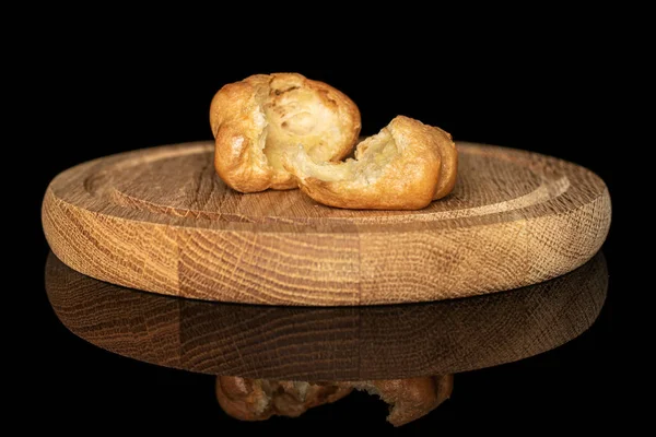 Golden baked profiterole isolated on black glass — Stock Photo, Image