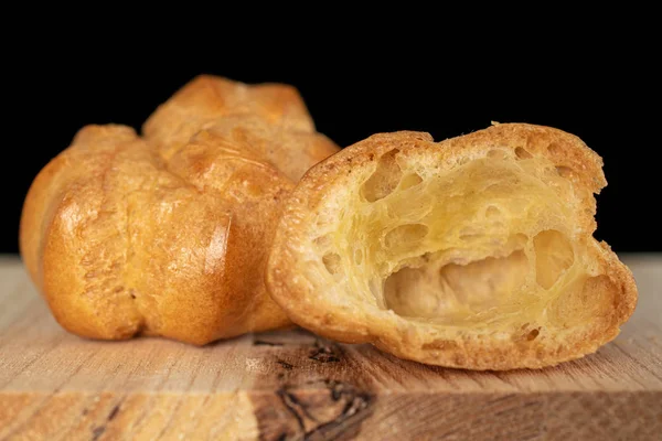 Gouden gebakken profiterole geïsoleerd op zwart glas — Stockfoto