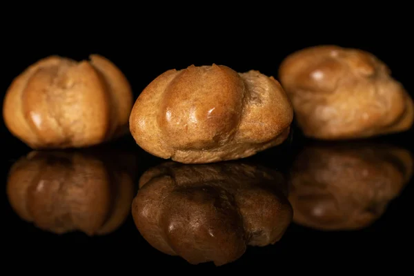 Profiterol al horno dorado aislado en vidrio negro —  Fotos de Stock