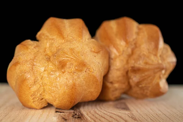 Gouden gebakken profiterole geïsoleerd op zwart glas — Stockfoto