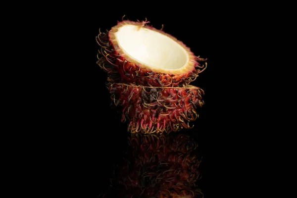 Frischer roter Rambutan isoliert auf schwarzem Glas — Stockfoto