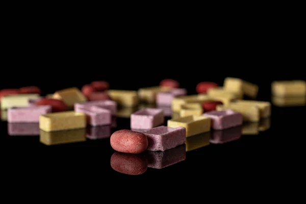 Sladké pastelové bonbóny izolované na černém skle — Stock fotografie