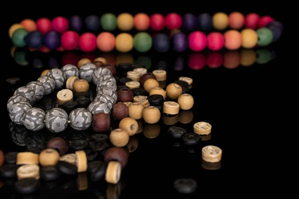 Kleurrijke houten kraal geïsoleerd op zwart glas — Stockfoto