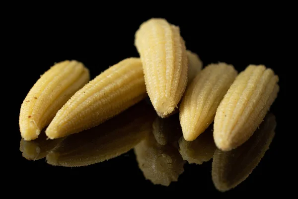 Pickled baby corn isolated on black glass — Stock Photo, Image