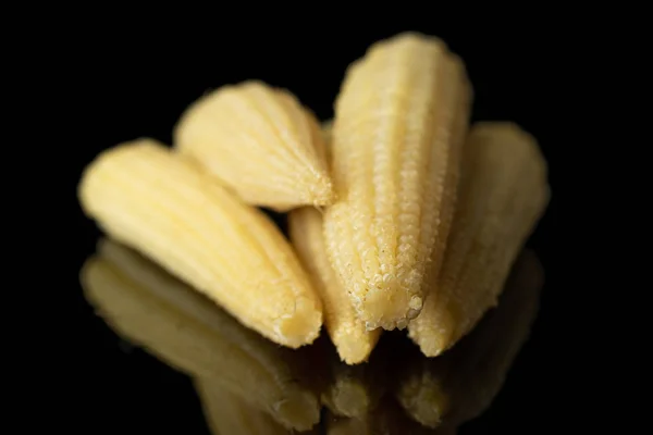 Pickled baby corn isolated on black glass — Stock Photo, Image