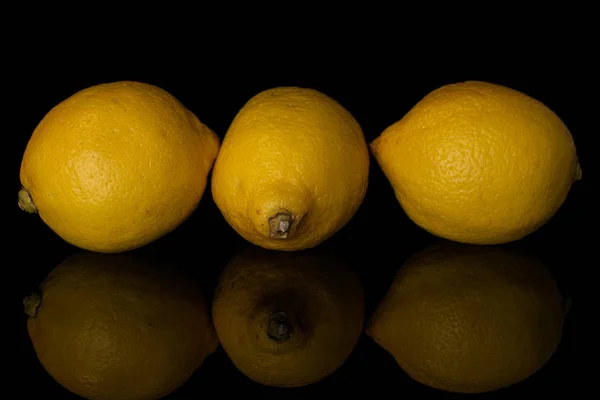 Čerstvý žlutý citrón izolovaný na černém skle — Stock fotografie