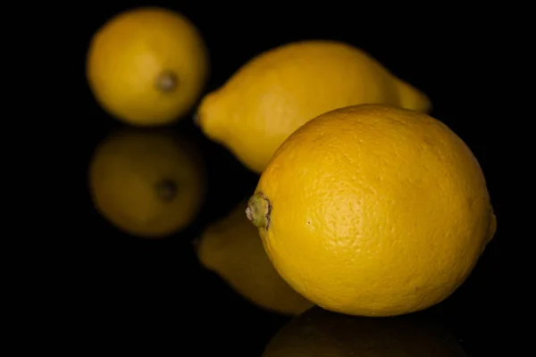 Limão amarelo fresco isolado em vidro preto — Fotografia de Stock