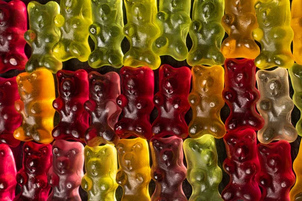 Bunte Gummibärchen auf grauem Stein — Stockfoto