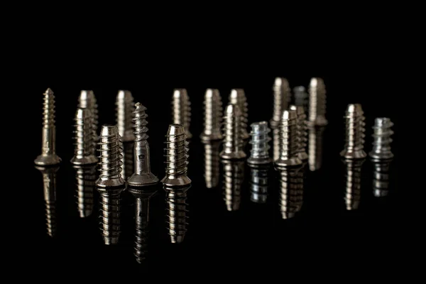 Glossy metallic bolt isolated on black glass — Stock Photo, Image