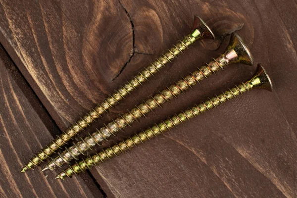 Glänzend metallischer Bolzen auf braunem Holz — Stockfoto