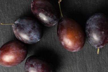 Gri taşın üzerinde tatlı mor erik