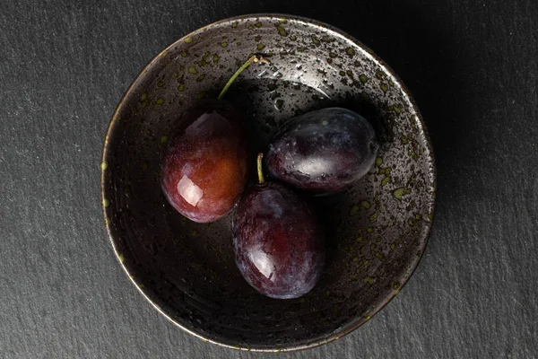 Sweet purple plum on grey stone