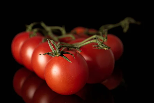 Frische rote Tomate isoliert auf schwarzem Glas — Stockfoto