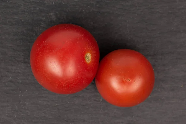 Tomate vermelho fresco sobre pedra cinzenta — Fotografia de Stock