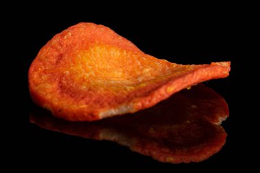 Kurutulmuş sebze cipsi siyah camda izole edilmiş.