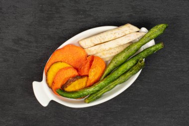 Gri taşta kurutulmuş sebze cipsi.