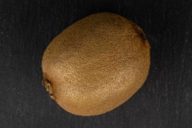 Gri taşın üzerinde egzotik kahverengi kivi meyvesi