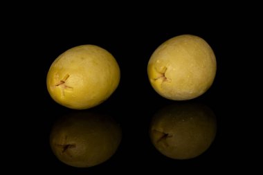 Yeşil salamura edilmiş zeytin siyah camda izole edilmiş.