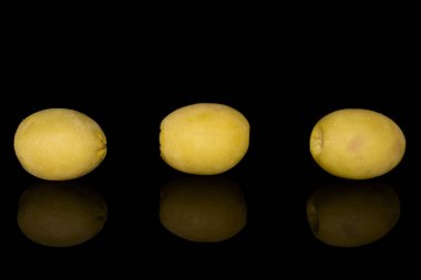 Yeşil salamura edilmiş zeytin siyah camda izole edilmiş.