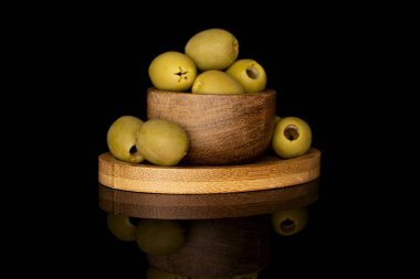 Yeşil salamura edilmiş zeytin siyah camda izole edilmiş.