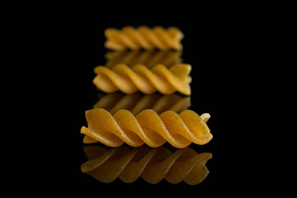 Fusilli todo seco isolado em vidro preto — Fotografia de Stock