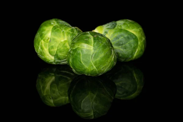 Fresh brussels sprout isolated on black glass — Stock Photo, Image