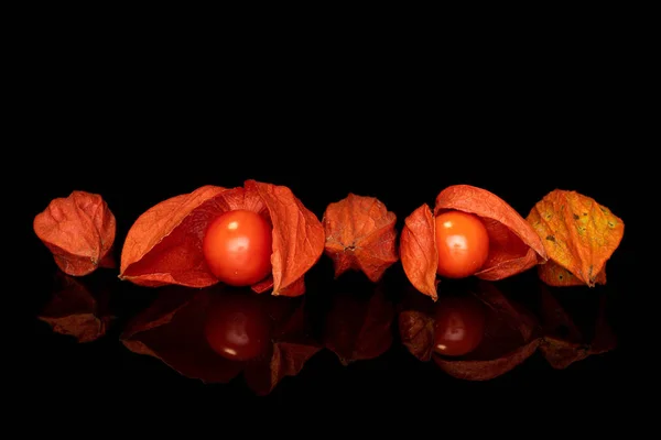 Frische orange Physalis isoliert auf schwarzem Glas — Stockfoto