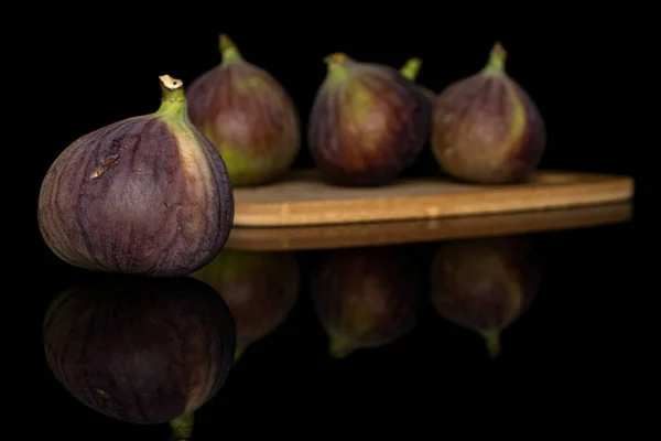 Sweet purple fig isolated on black glass