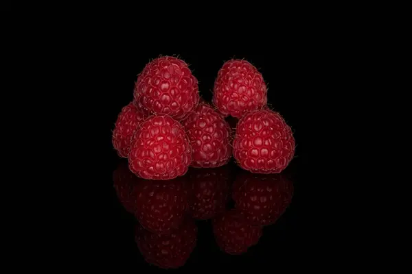 Frische rote Himbeere isoliert auf schwarzem Glas — Stockfoto