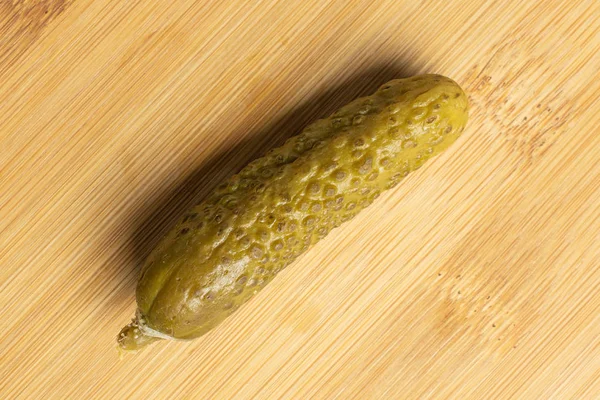 Sour green pickles on light wood — Stock Photo, Image