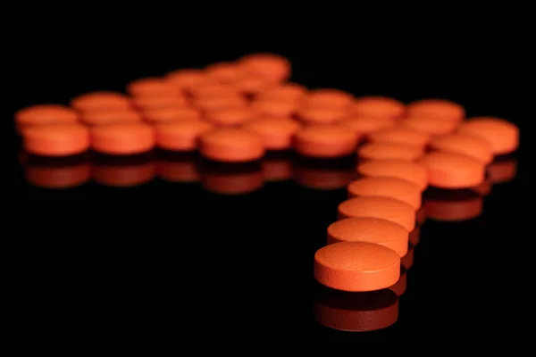 Tableta de farmacia naranja aislada en vidrio negro —  Fotos de Stock