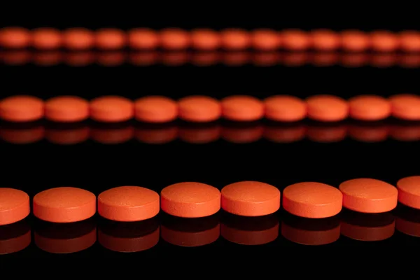 Oranje apotheek tablet geïsoleerd op zwart glas — Stockfoto