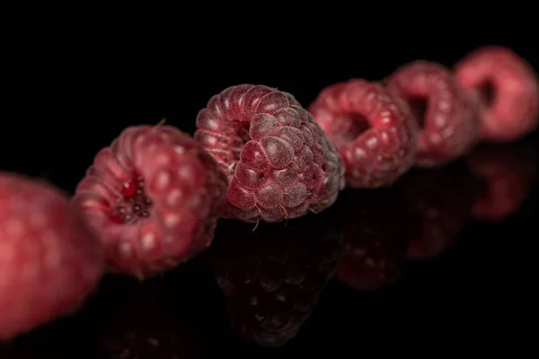 Fresh crimson raspberry isolated on black glass — Stock Photo, Image