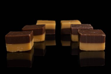 Siyah camda izole edilmiş karamel çikolata şekeri.