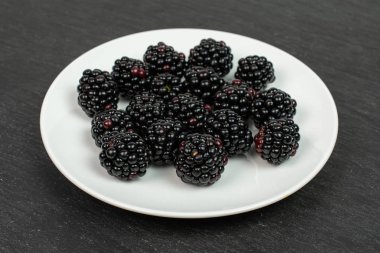 Gri taşın üzerinde taze siyah böğürtlen